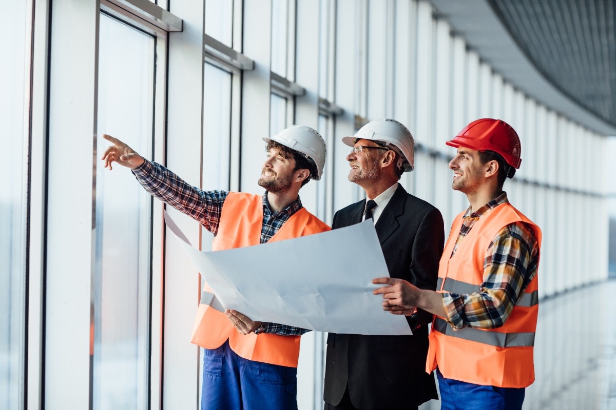Construction workers reviewing blueprints on site